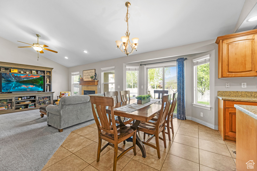 Dining room with light tile patterned flooring, vaulted ceiling, and recessed lighting