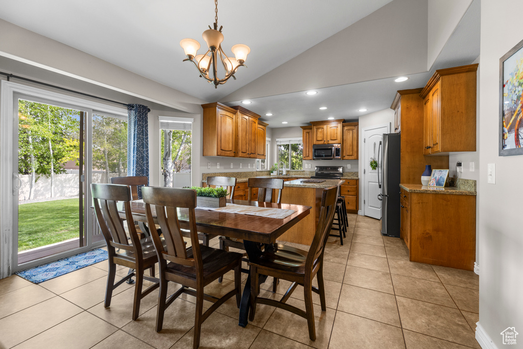 Dining room with plenty of natural light, a notable chandelier, recessed lighting, and lofted ceiling