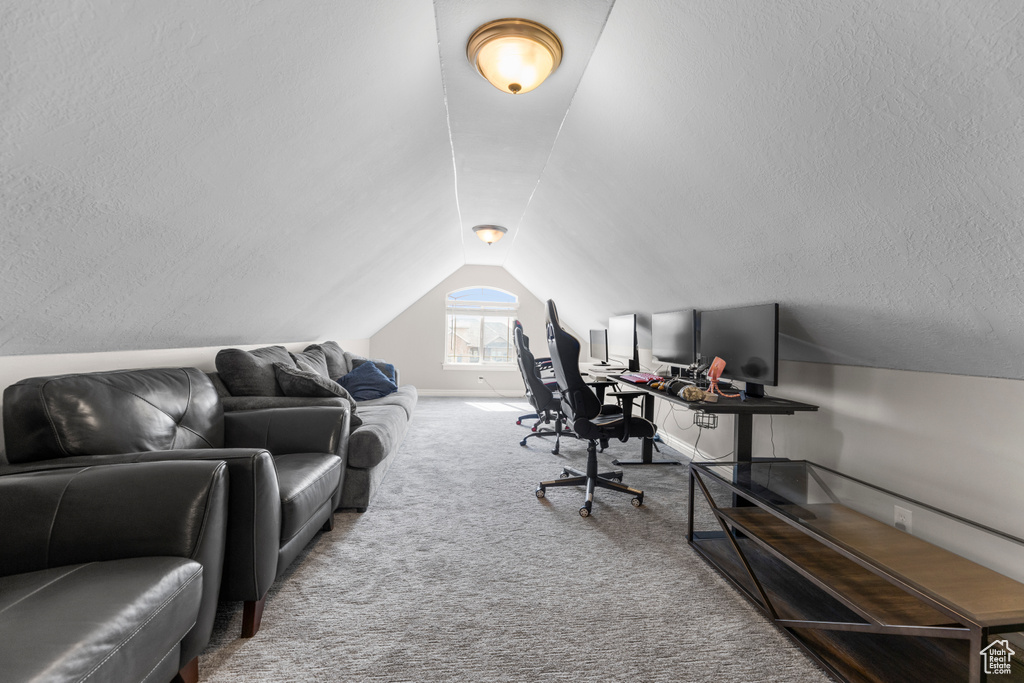Carpeted office space featuring vaulted ceiling