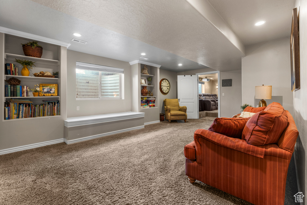 Carpeted living area with baseboards, recessed lighting, a textured ceiling, and visible vents