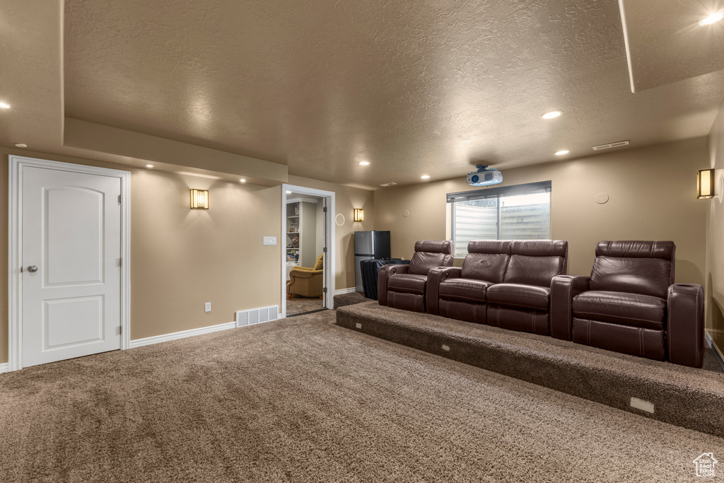 Carpeted home theater room with baseboards, recessed lighting, a textured ceiling, and visible vents