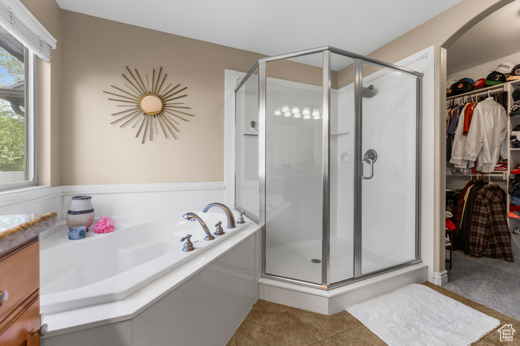 Bathroom with vanity, tile patterned flooring, a bath, a spacious closet, and a shower stall