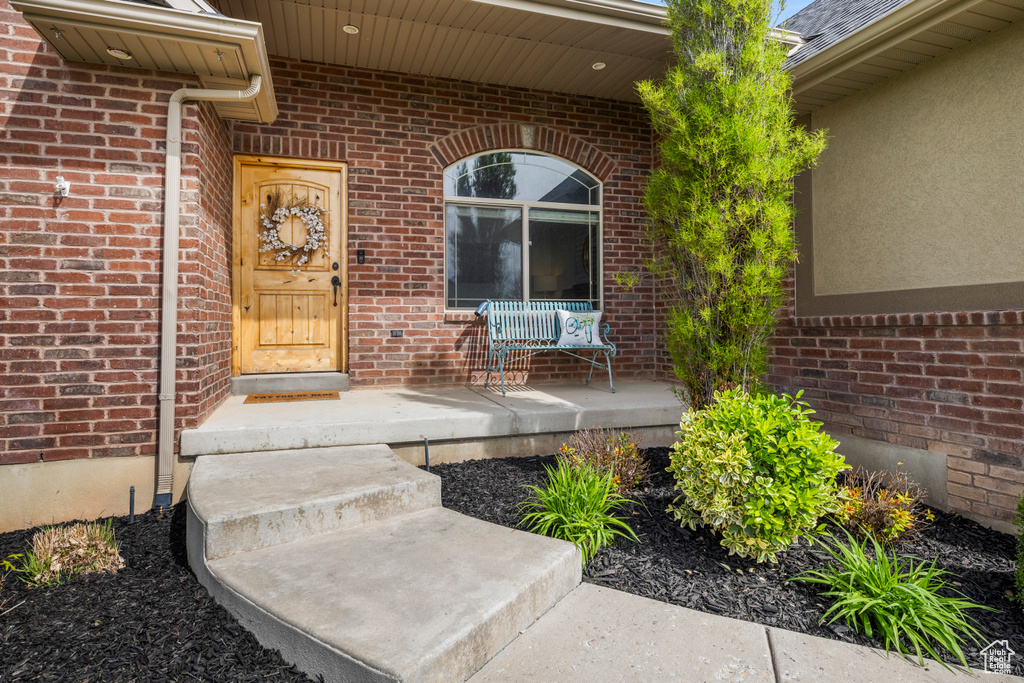 View of exterior entry with brick siding