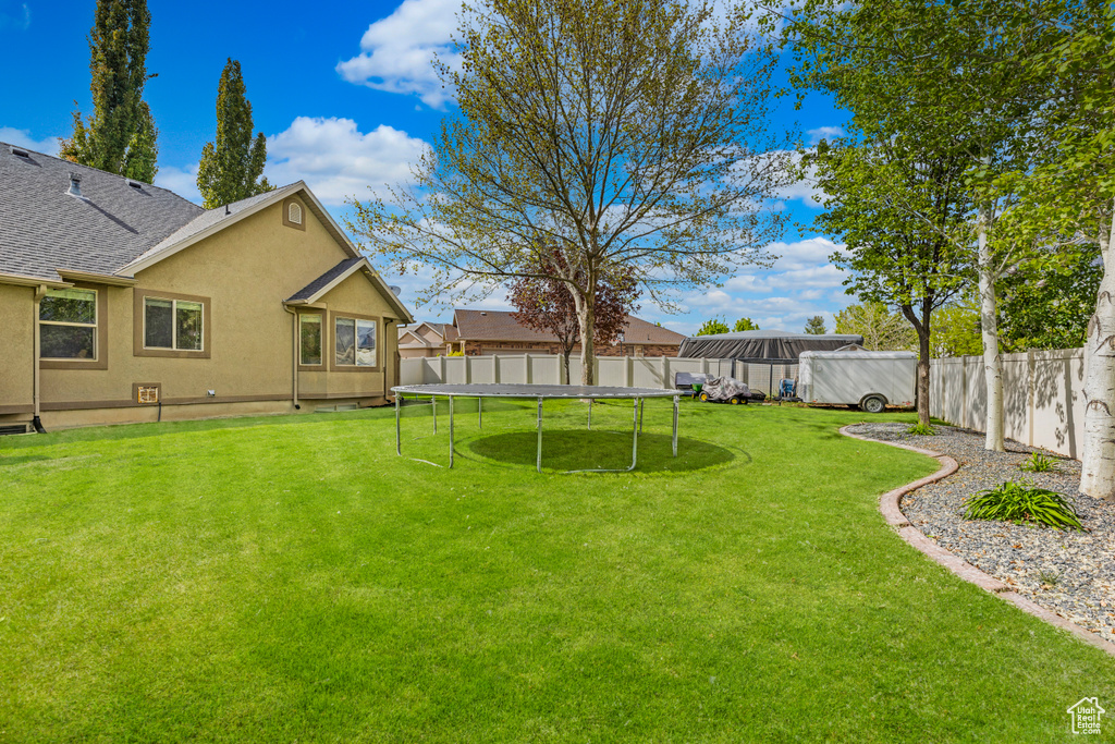 View of yard with a fenced backyard and a trampoline