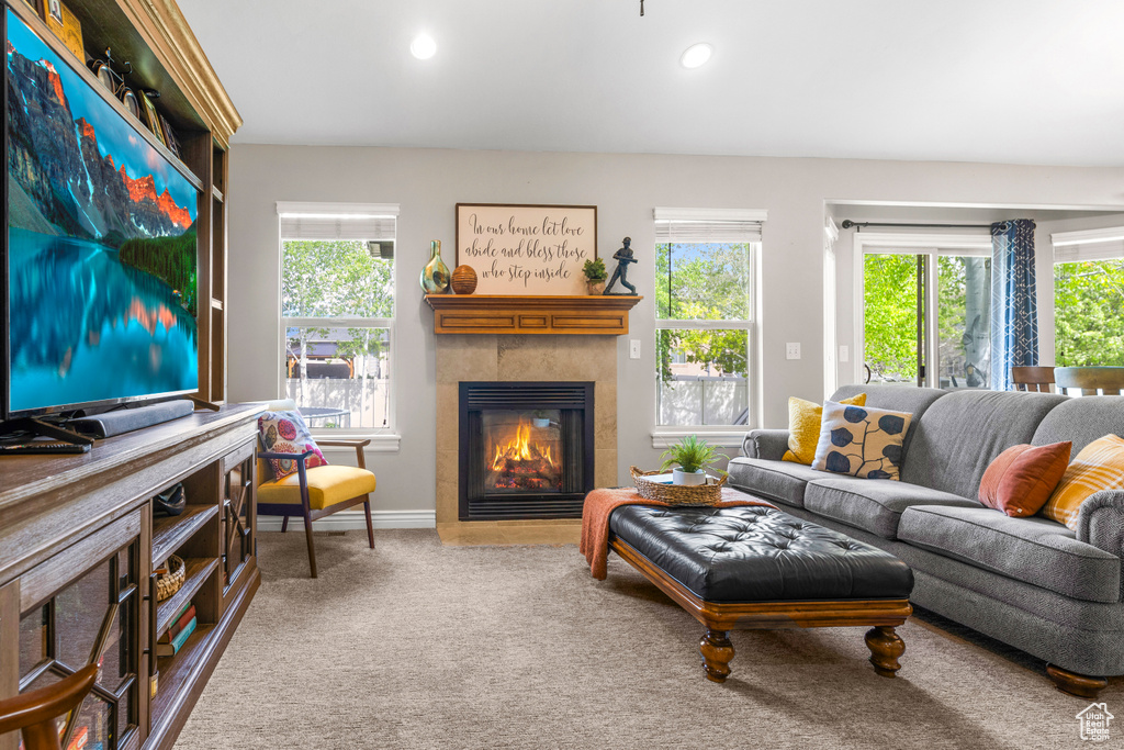 Living area with a tiled fireplace, plenty of natural light, and recessed lighting