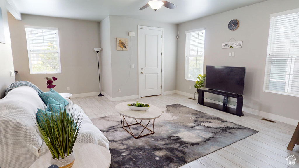 Living area featuring healthy amount of natural light, wood finished floors, and a ceiling fan