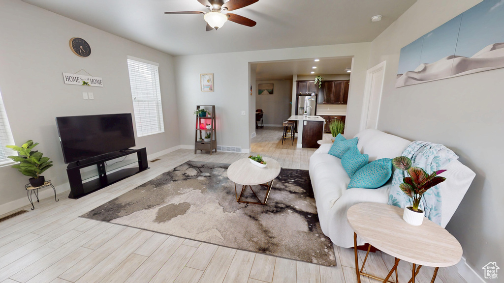 Living room featuring a ceiling fan and light wood-style flooring