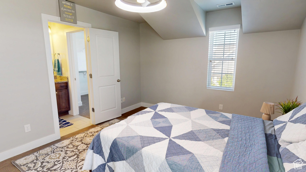 Bedroom with baseboards, light wood-type flooring, connected bathroom, and visible vents