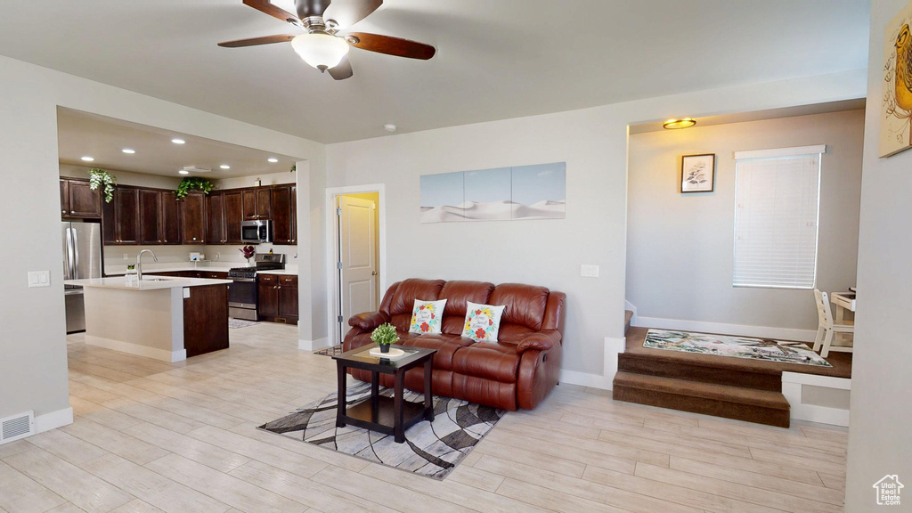 Living area featuring light wood-style floors, ceiling fan, recessed lighting, and visible vents