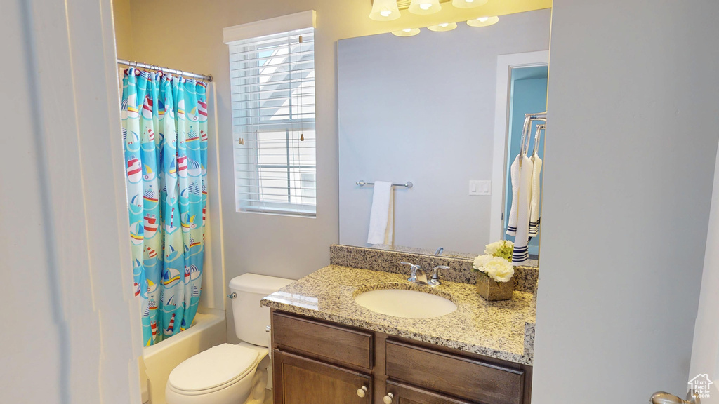 Full bathroom featuring vanity, toilet, and shower / tub combo with curtain