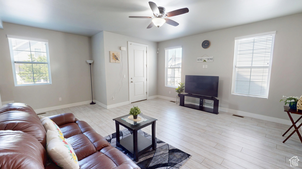 Living room featuring baseboards, light wood-style flooring, and ceiling fan