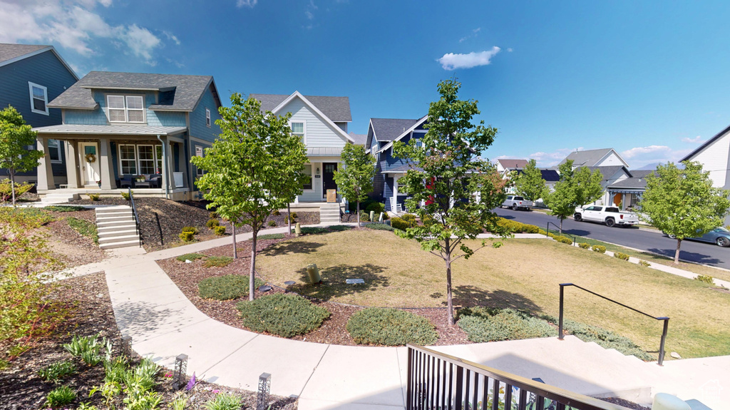 View of front facade featuring covered porch, a residential view, and a shingled roof