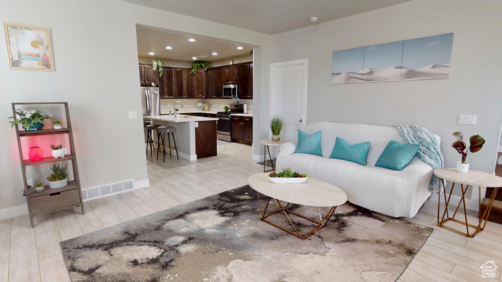 Living room featuring light wood finished floors and recessed lighting