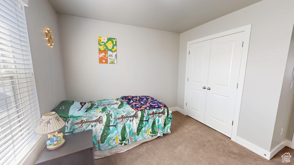 Carpeted bedroom with baseboards and a closet