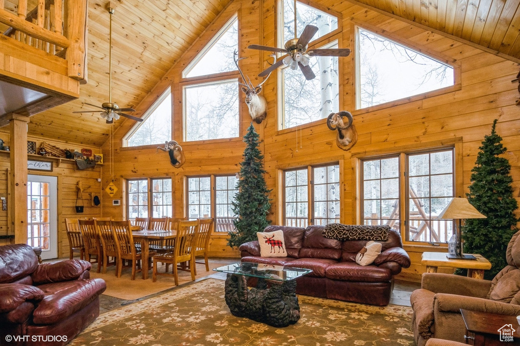 Living room with ceiling fan, wooden ceiling, a wealth of natural light, and high vaulted ceiling