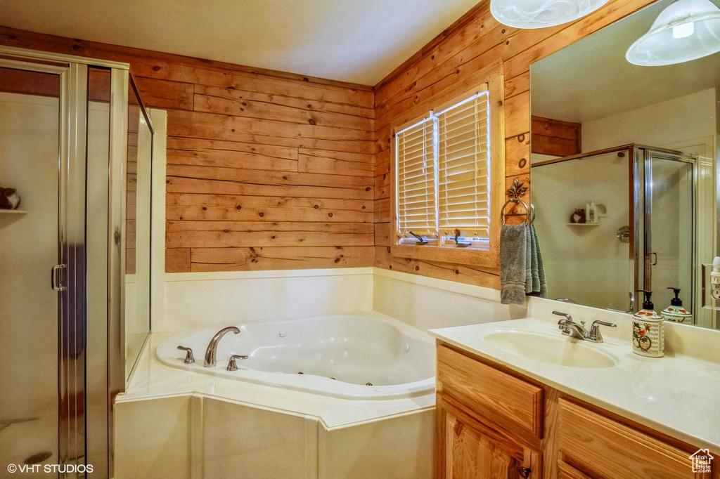 Bathroom with vanity, wood walls, a shower stall, and a tub with jets