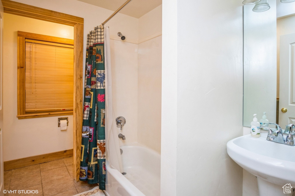 Full bath with baseboards, a sink, tile patterned floors, and shower / bath combination with curtain