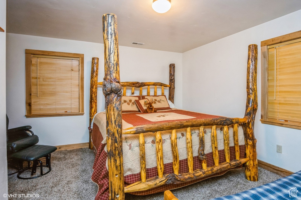 Bedroom with visible vents, carpet flooring, and baseboards