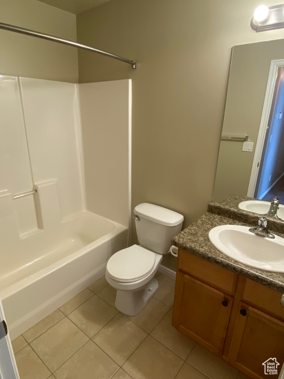 Bathroom with tile patterned flooring, vanity, toilet, baseboards, and washtub / shower combination