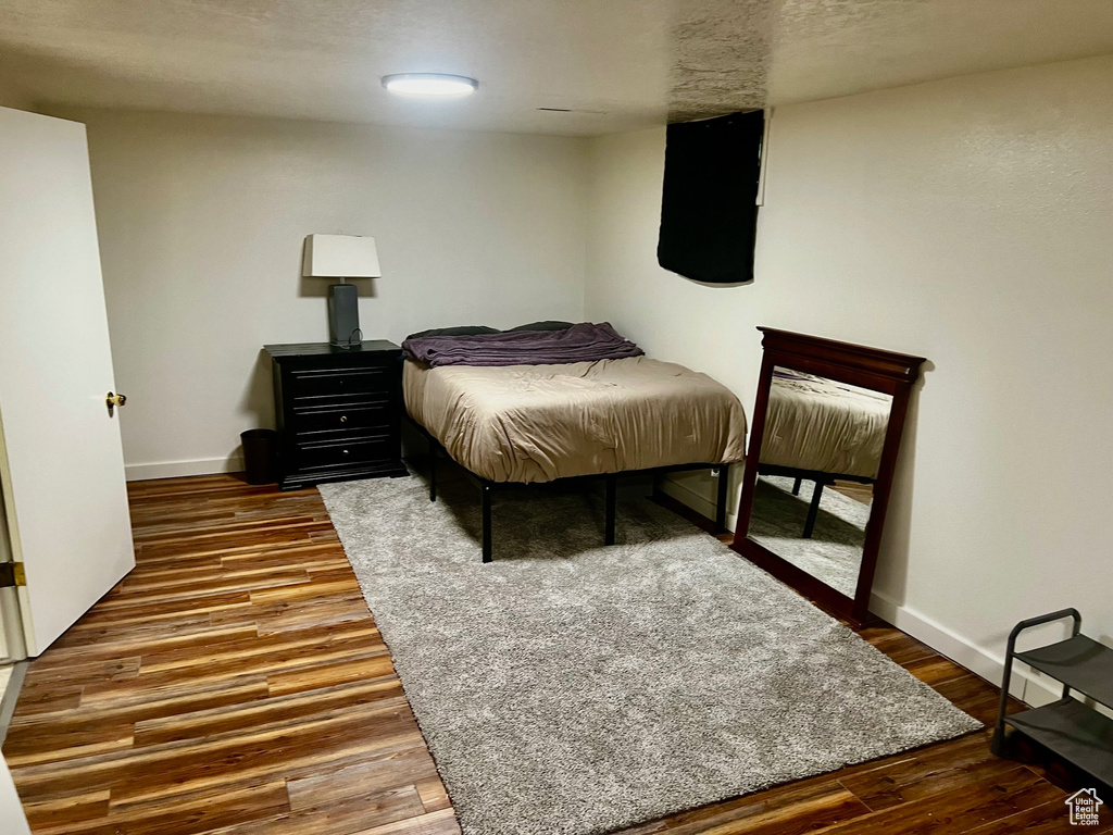 Bedroom featuring baseboards and wood finished floors
