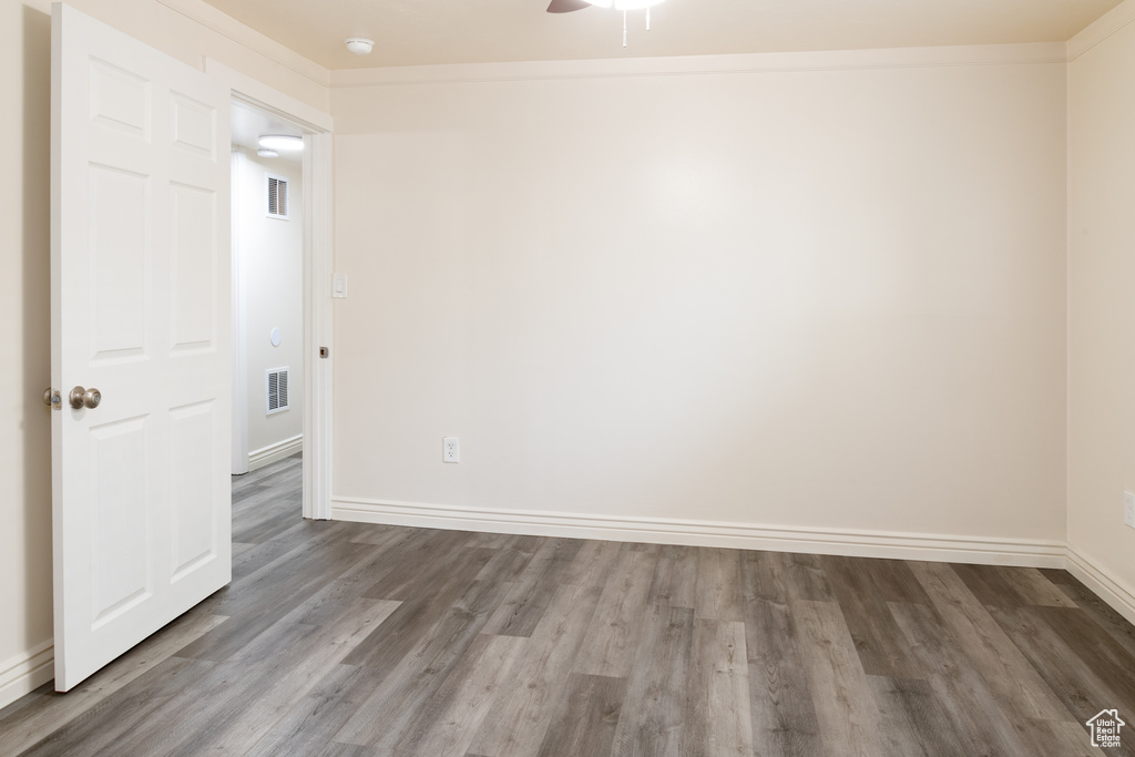 Empty room featuring visible vents, baseboards, ceiling fan, and wood finished floors