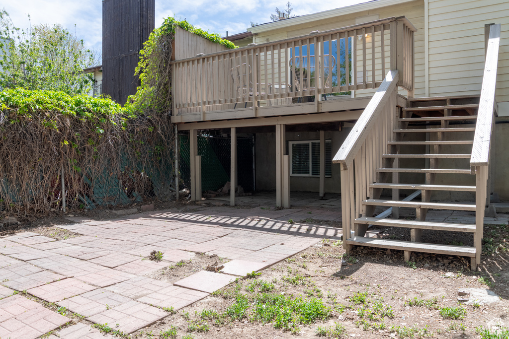Back of house featuring stairway, a deck, and a patio