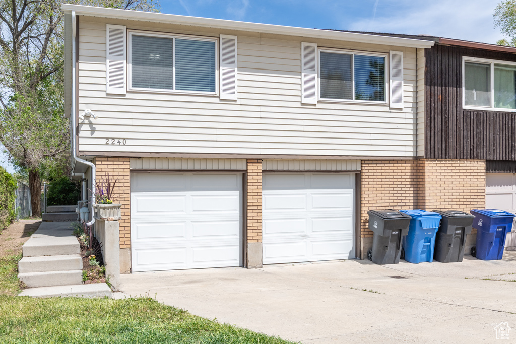 Exterior space featuring brick siding, a garage, and concrete driveway