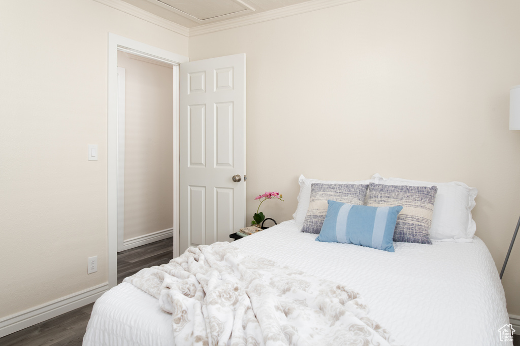 Bedroom featuring baseboards, ornamental molding, and dark wood-style floors