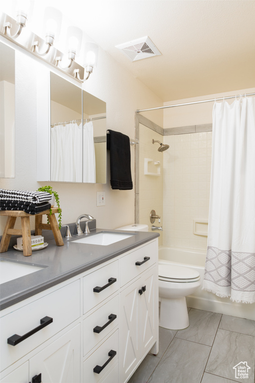 Full bathroom with vanity, toilet, marble finish floor, shower / tub combo, and visible vents