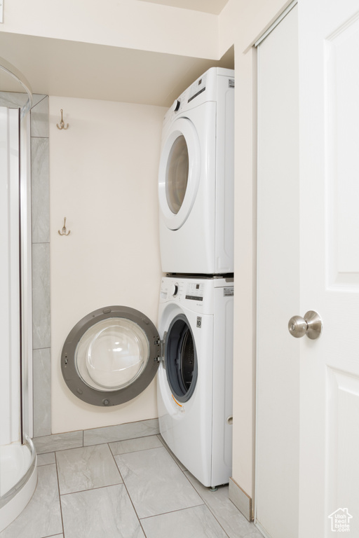 Laundry area with marble finish floor, laundry area, and stacked washer and clothes dryer