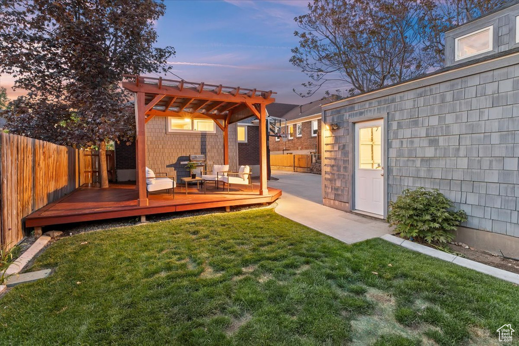 Back of property featuring a lawn, a pergola, a fenced backyard, and a deck