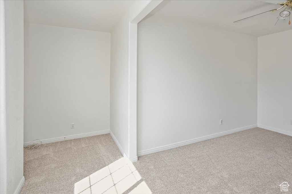 Carpeted spare room with baseboards and ceiling fan