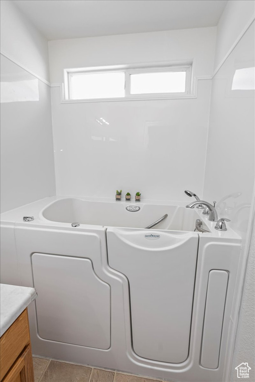 Bathroom with plenty of natural light, a garden tub, and vanity