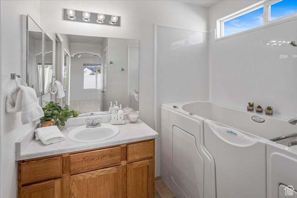 Full bathroom with vanity and a washtub