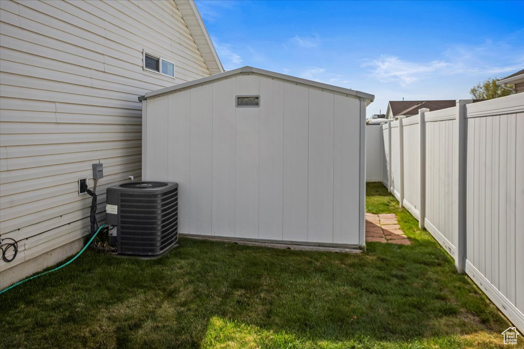 View of shed with a fenced backyard and central AC