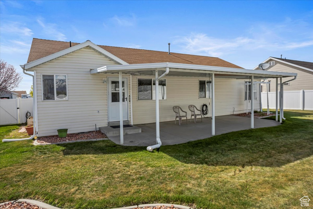 Rear view of house featuring fence, a gate, a shingled roof, a patio area, and a yard