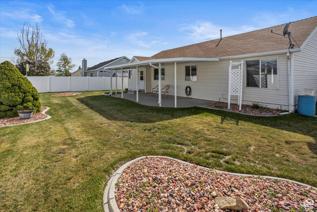 View of yard with fence and a patio