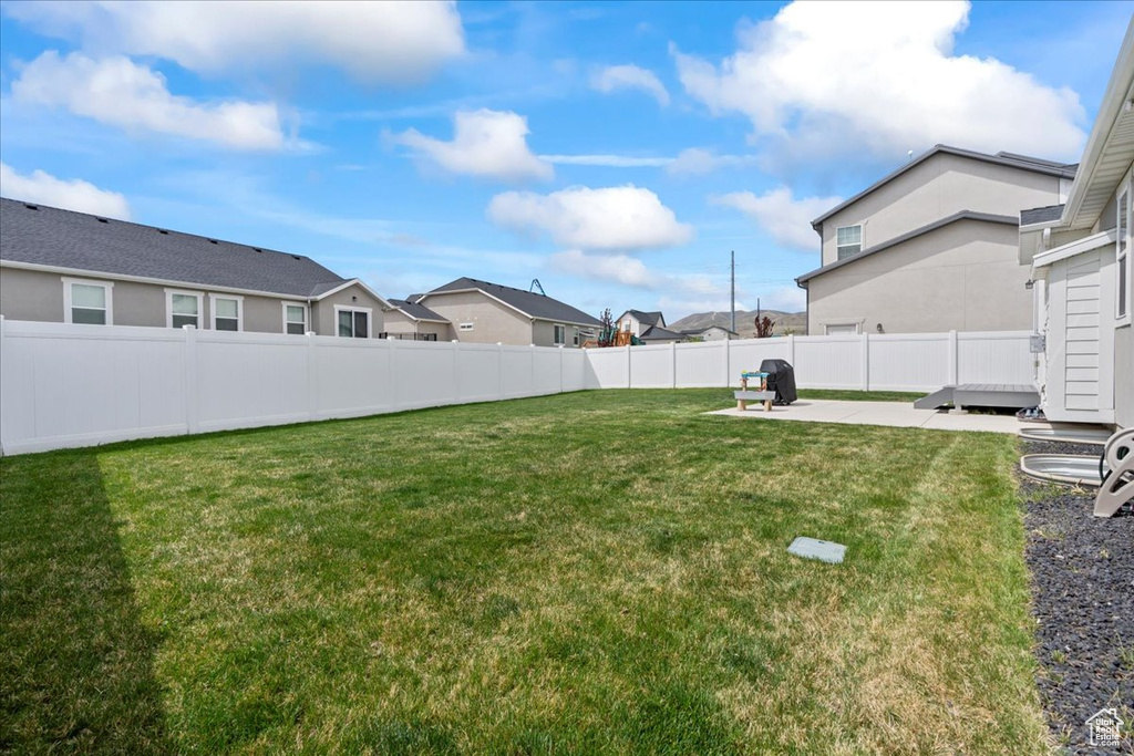 View of yard featuring fence, a patio area, and a residential view