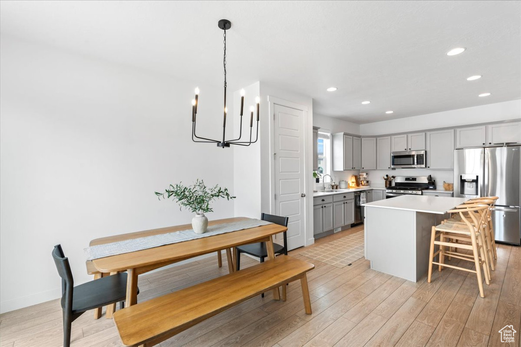 Kitchen with gray cabinets, stainless steel appliances, a notable chandelier, and recessed lighting