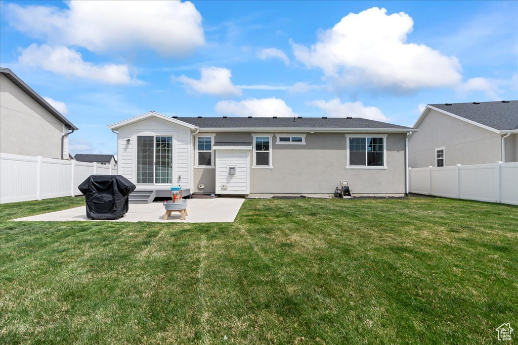 Back of property with a lawn, a fenced backyard, and a patio area