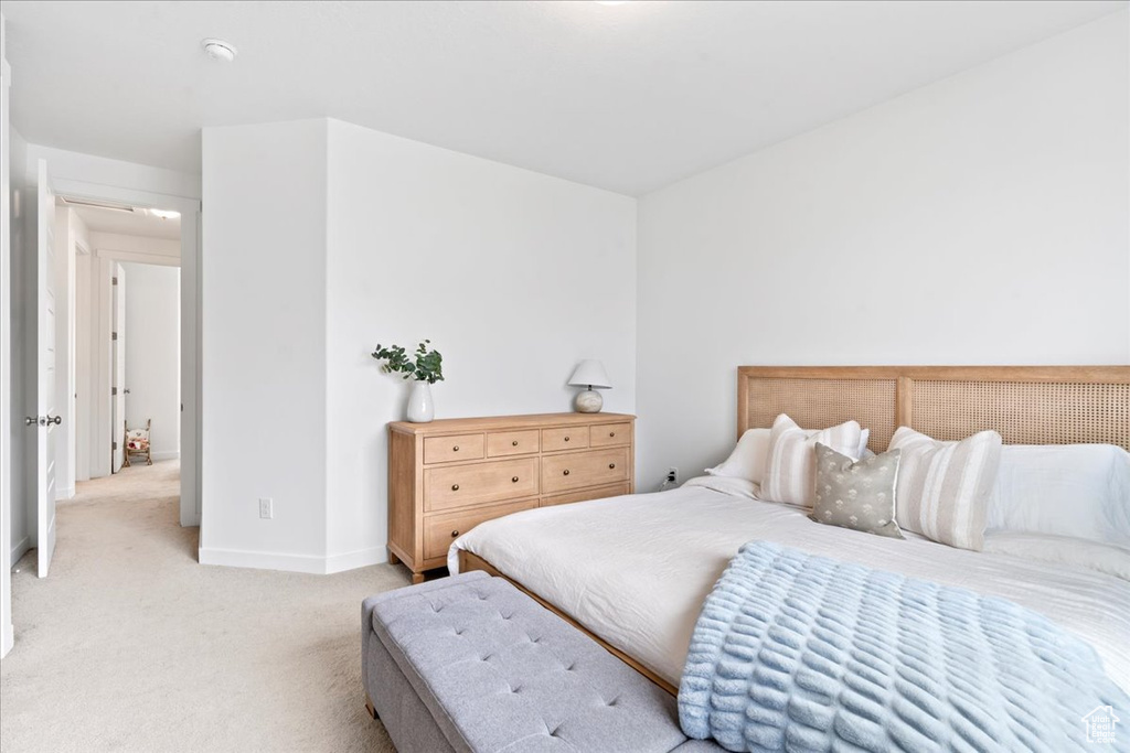 Bedroom with baseboards and light carpet
