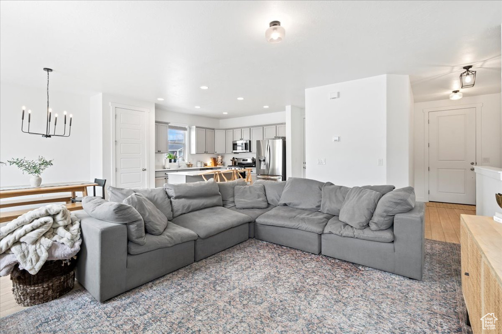Living area featuring recessed lighting, a notable chandelier, and light wood-style flooring