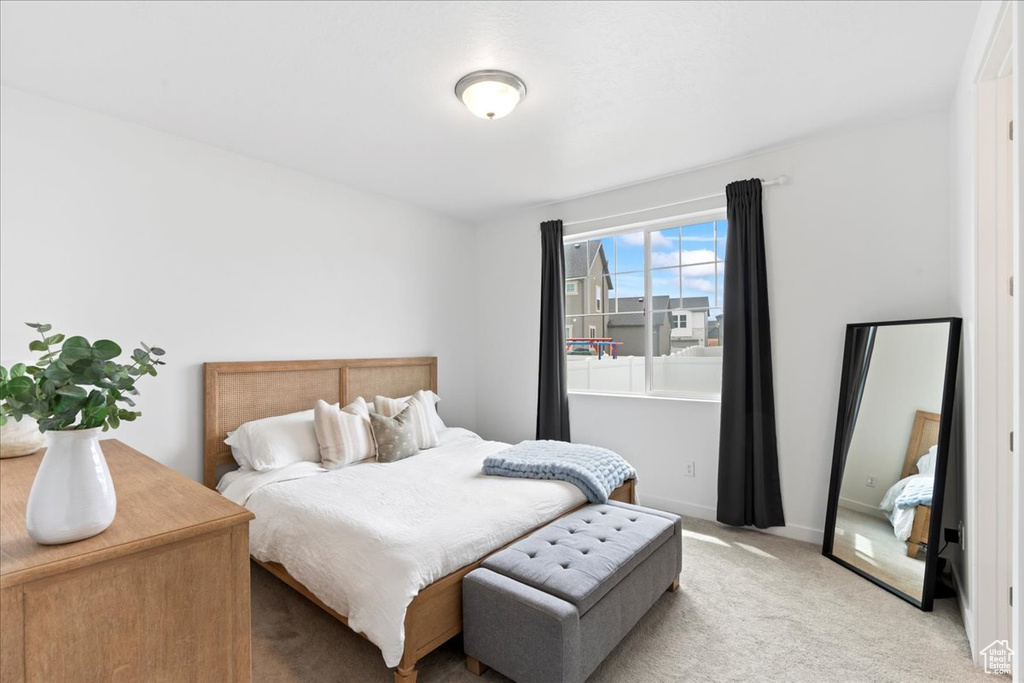 Bedroom featuring baseboards and light carpet
