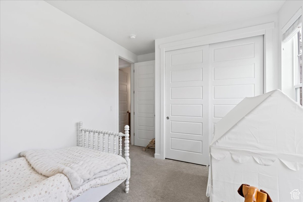 Carpeted bedroom featuring a closet