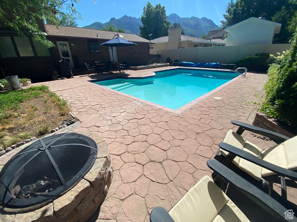View of swimming pool featuring a patio, a fenced backyard, a mountain view, and a fenced in pool