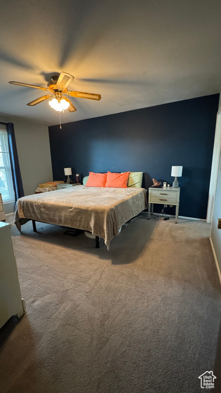 Carpeted bedroom with baseboards and a ceiling fan