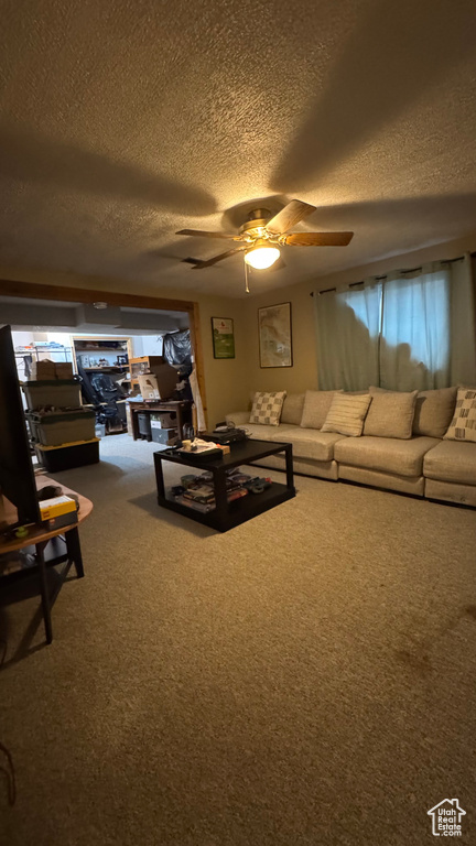 Living room with carpet flooring, a ceiling fan, and a textured ceiling
