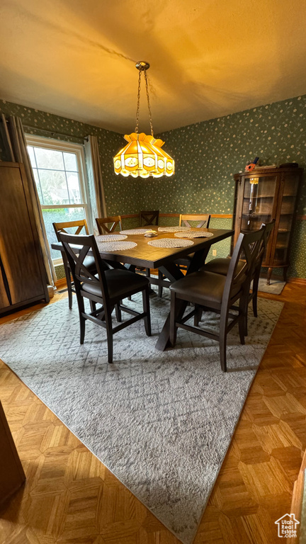 Dining area featuring wallpapered walls and a chandelier