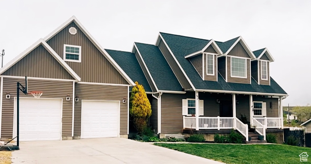 Craftsman-style home with a porch, driveway, board and batten siding, and a front lawn