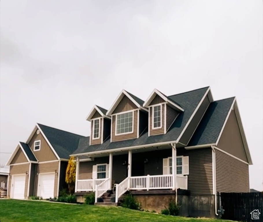 Craftsman-style home with fence, covered porch, and a front yard